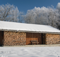 fileadmin/roha/images_galerie/Winter/LANDA-STAD-UF-WIN-0002-D-roha-Landart-Stadel-Ufering-Winter-Stadel-Brennholz-Schnee-Bank.png