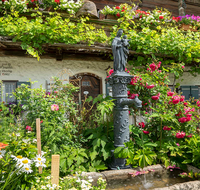 fileadmin/roha/Interessantes-in-Kurzform/ab-5-2022/LANDA-BLUMENSCHM-PET-0001-10-D-roha-Landart-Blumenschmuck-Petting-Brunnen-Madonna.png