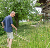 fileadmin/roha/images_galerie/Menschen/GAR-WIESE-MAEH-0007-D-roha-Garten-Blumen-Wiese-Maehen-Sense-Haus.png