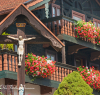 fileadmin/roha/images_galerie/orte_landschaft/Siegsdorf/KKKM-SIEG-MOLB-0001-D-roha-Wegkreuz-Christus-Siegsdorf-Molberting-Bauernhaus-Blumenschmuck.png