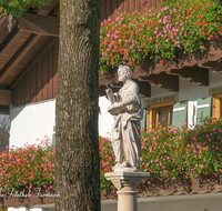 fileadmin/roha/images_galerie/orte_landschaft/Piding/PID-PET-PL-0004-D-roha-Piding-Petersplatz-Heiliger-Petrus-Statue-Marmor-Blumenschmuck.png