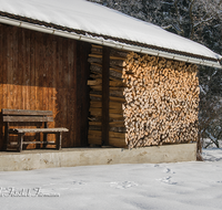 fileadmin/roha/images_galerie/Winter/LANDA-STAD-UF-WIN-0004-D-roha-Landart-Stadel-Ufering-Winter-Stadel-Brennholz-Schnee-Bank.png