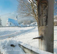 fileadmin/roha/images_galerie/orte_landschaft/Anger/Aufham/AUF-WI-0003-D-roha-Aufham-Anger-Winter-Schnee-Kirche-Hochstaufen-Brunnen.png