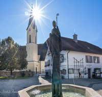 fileadmin/roha/images_galerie/orte_landschaft/Piding/PID-RUP-BR-0012-D-roha-Piding-Petersplatz-Rupertusbrunnen-Kirche-Sonne.png